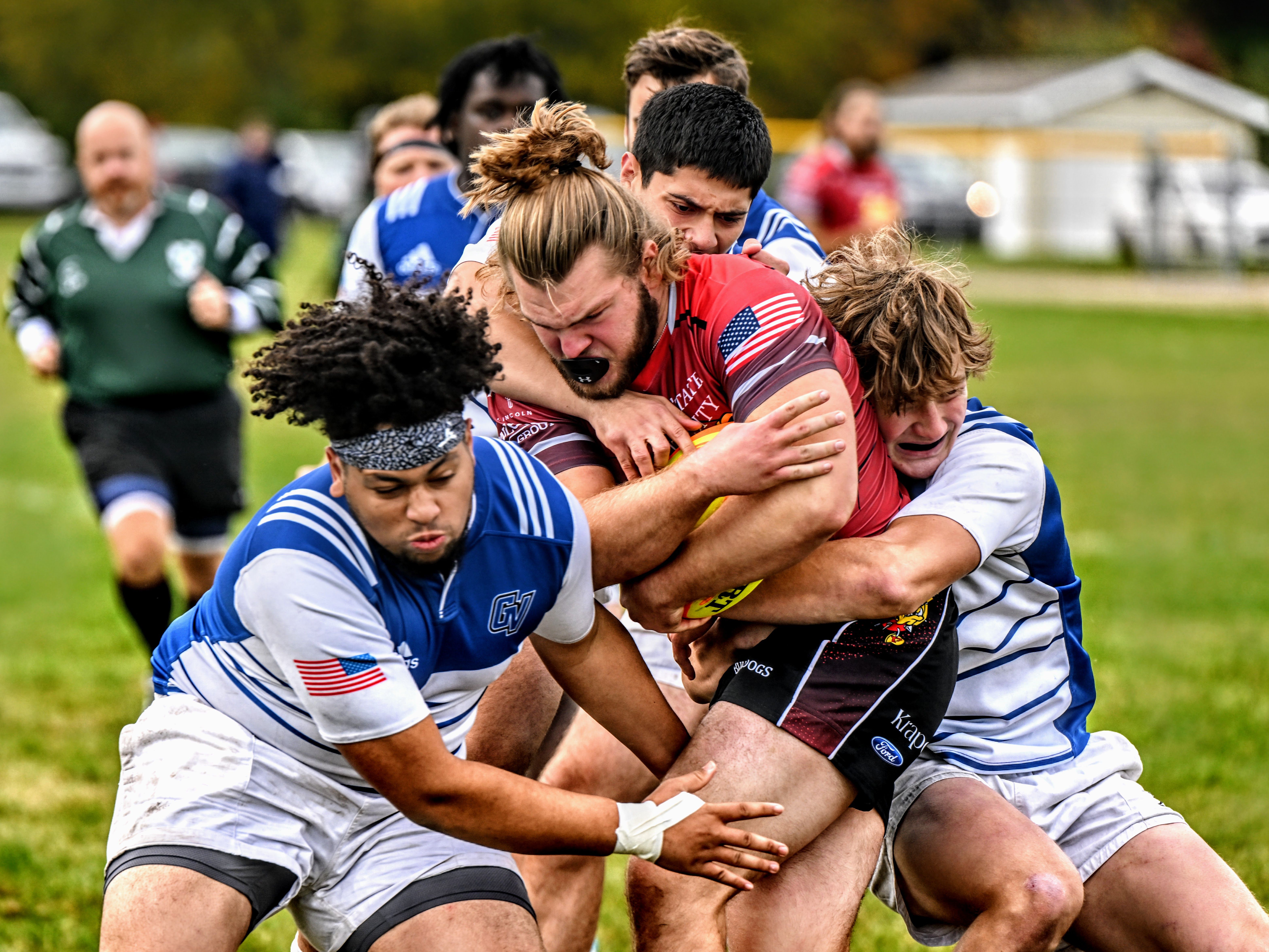 Ferris State ball carrier driving through a group tackle